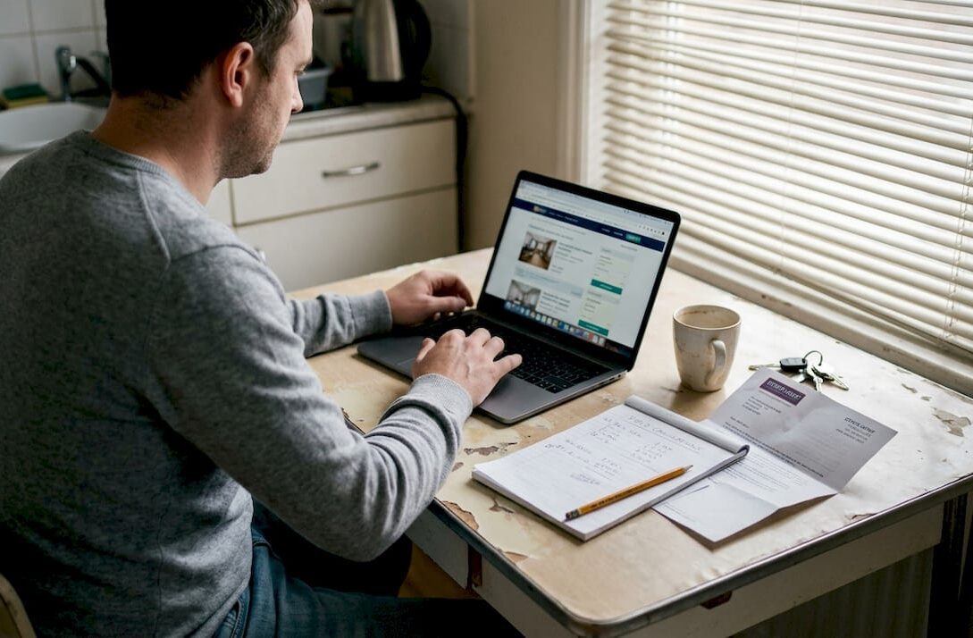Man reviewing property listings at kitchen table