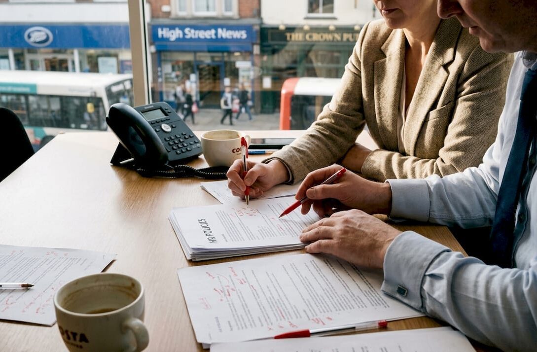 Small business managers reviewing printed workplace policies